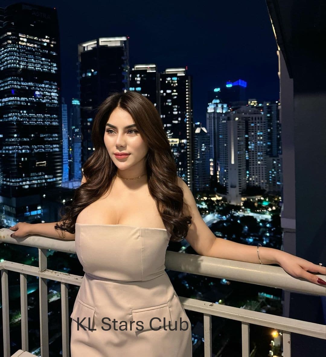 S-class Kuala Lumpur escort Victoria Qistina in a black cocktail dress, standing at a rooftop bar with KL city lights in the background.